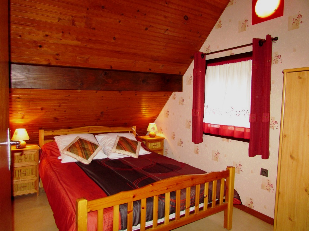 Chambre mansardée à l'étage avec grand lit de 140